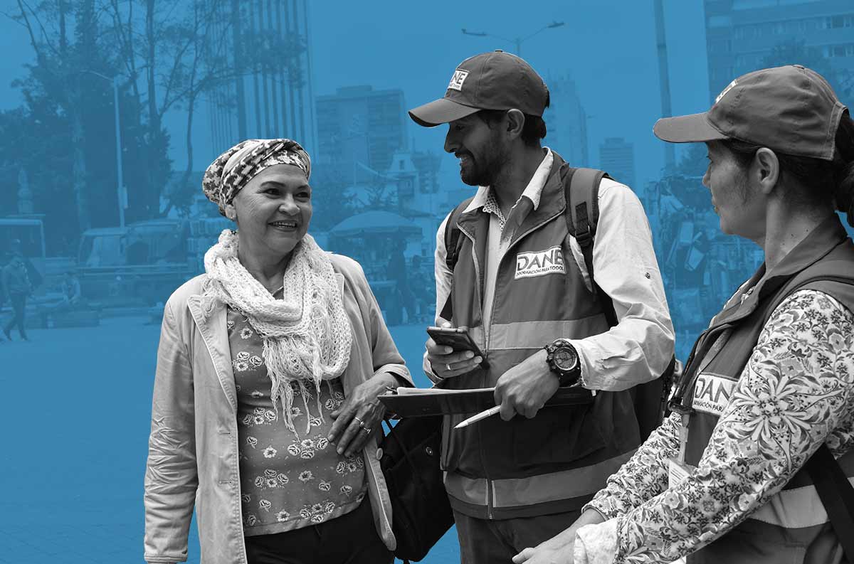 Señora mayor sonriéndole a dos censistas que le están hablando a ella